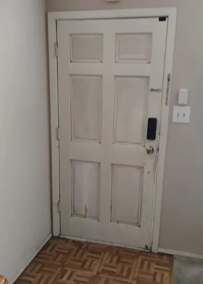 Interior view of the original worn wood entry door in a Novato home