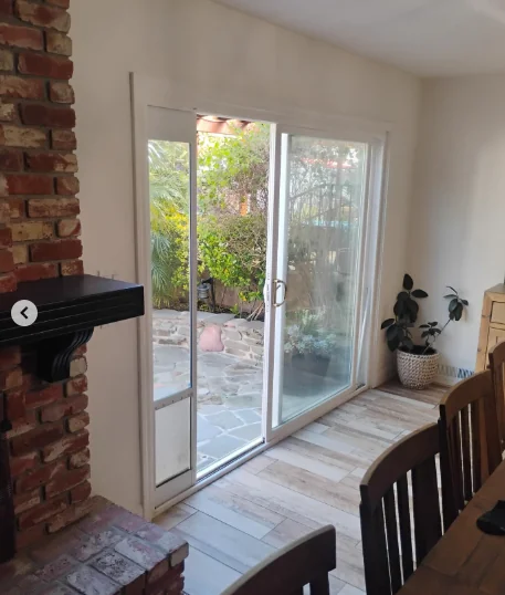 Interior view of a difficult-to-slide aluminum patio door before French-door conversion in Fremont