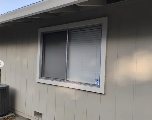 Old aluminum sliding window before replacement on a Danville home