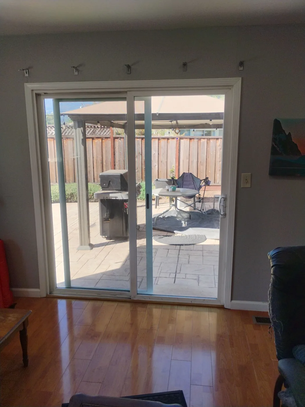Afternoon light through the new white-frame Anlin patio door across the hardwood floor of the San Jose living room