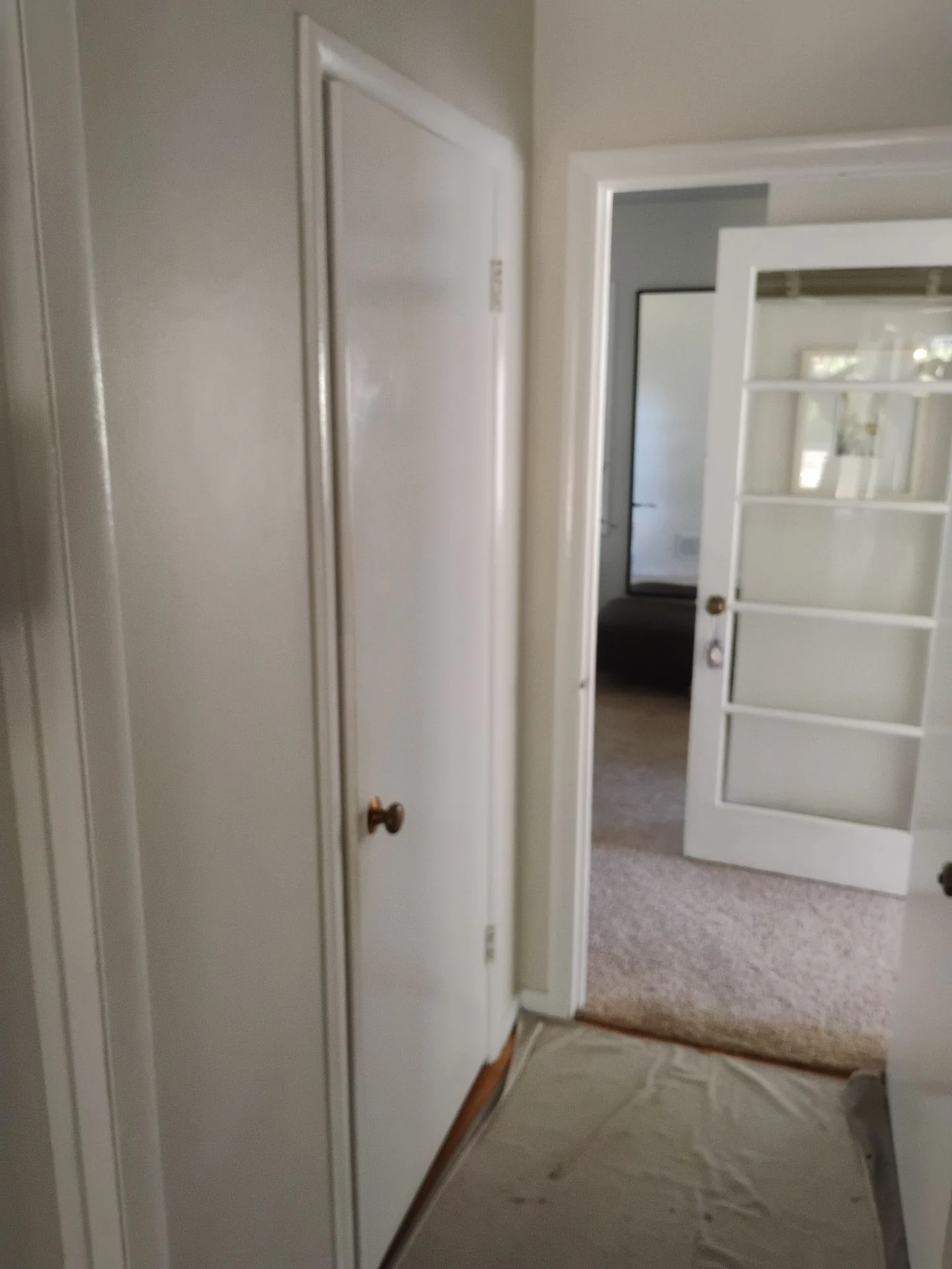 Before: close view of an original hollow-core interior door and dated brass knob in the San Carlos, CA home