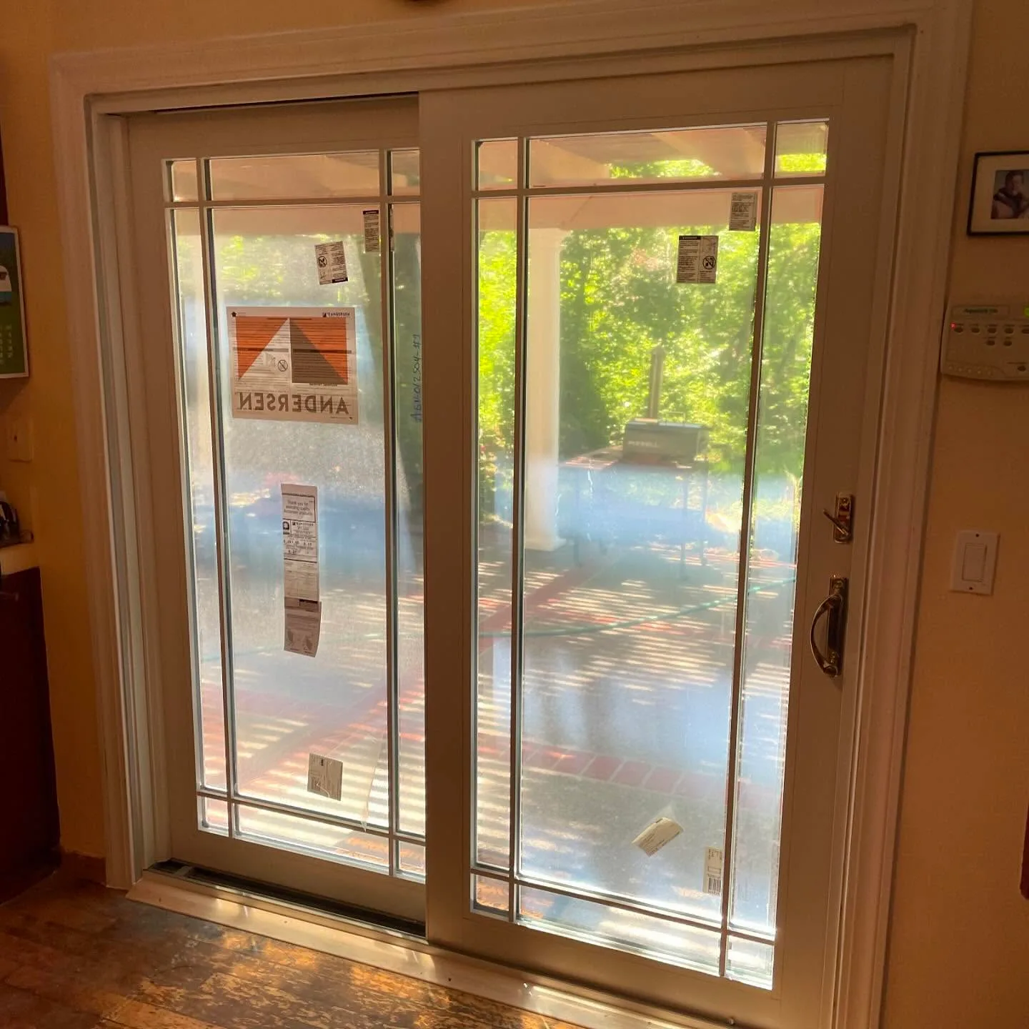 Interior view of an Andersen 400 Series Frenchwood patio door with divided-light glass and Newbury Bright Brass hardware in Novato, CA