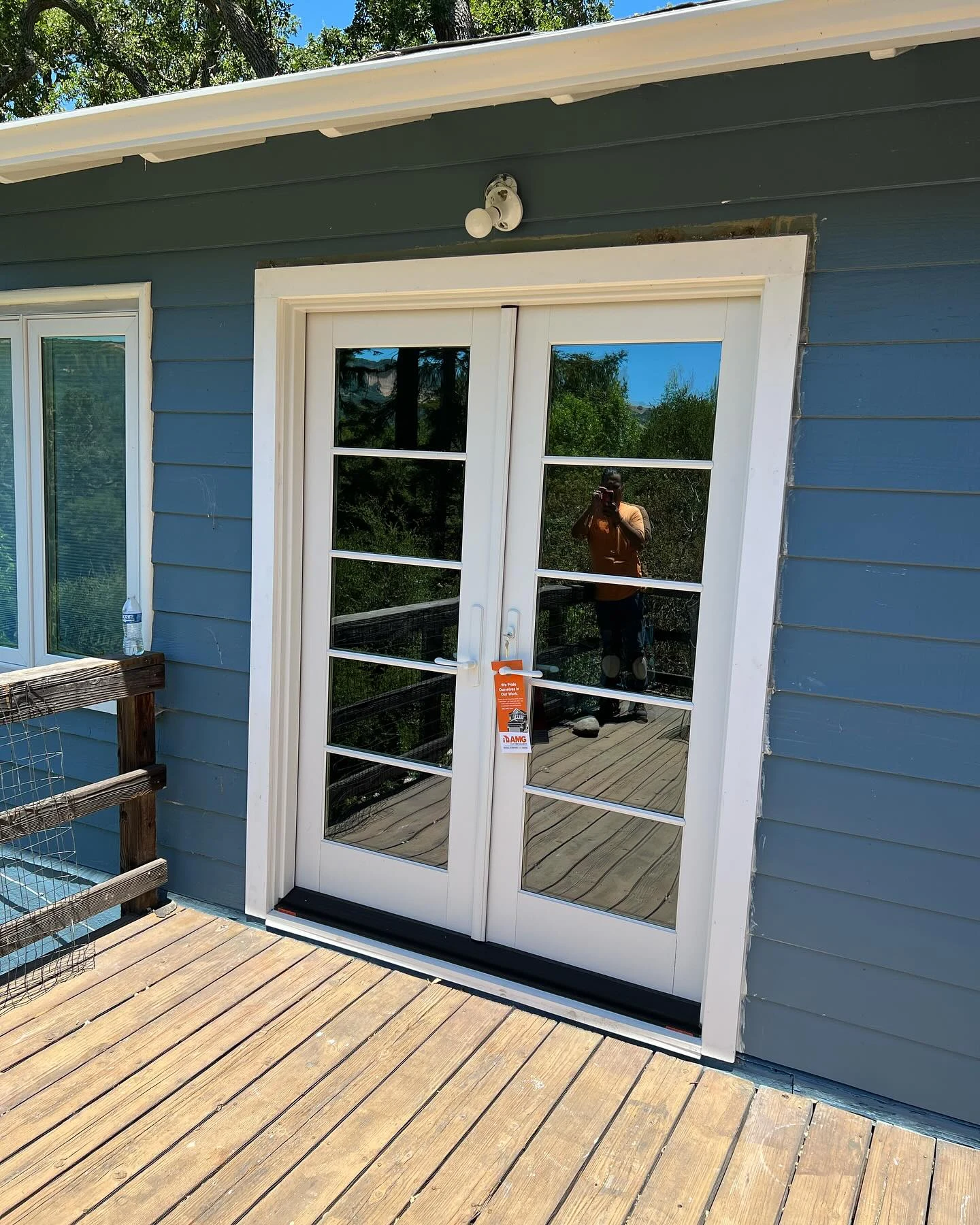 Exterior view of white Andersen E-Series French patio doors installed on a blue Orinda California home