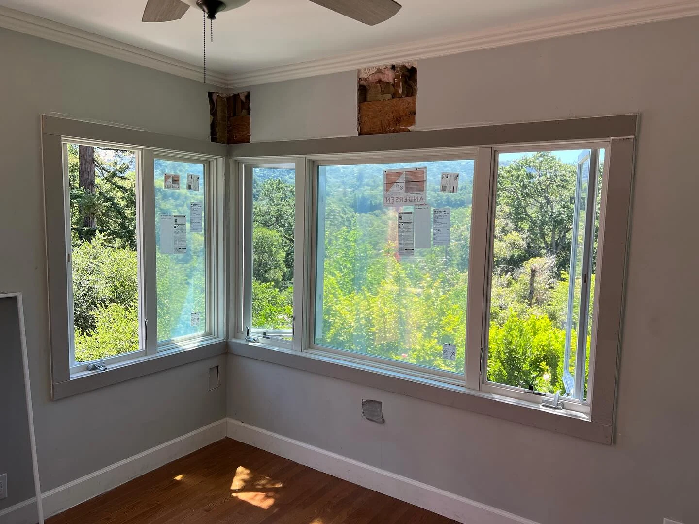 Interior installation view of white Andersen E-Series casement windows wrapping a corner room in Orinda, CA