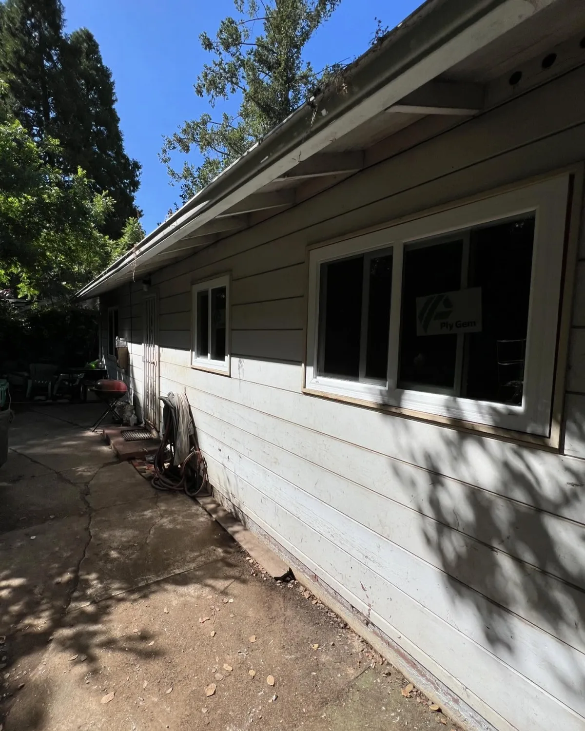 Multiple white PlyGem replacement windows installed along the side of an Oakland, CA home