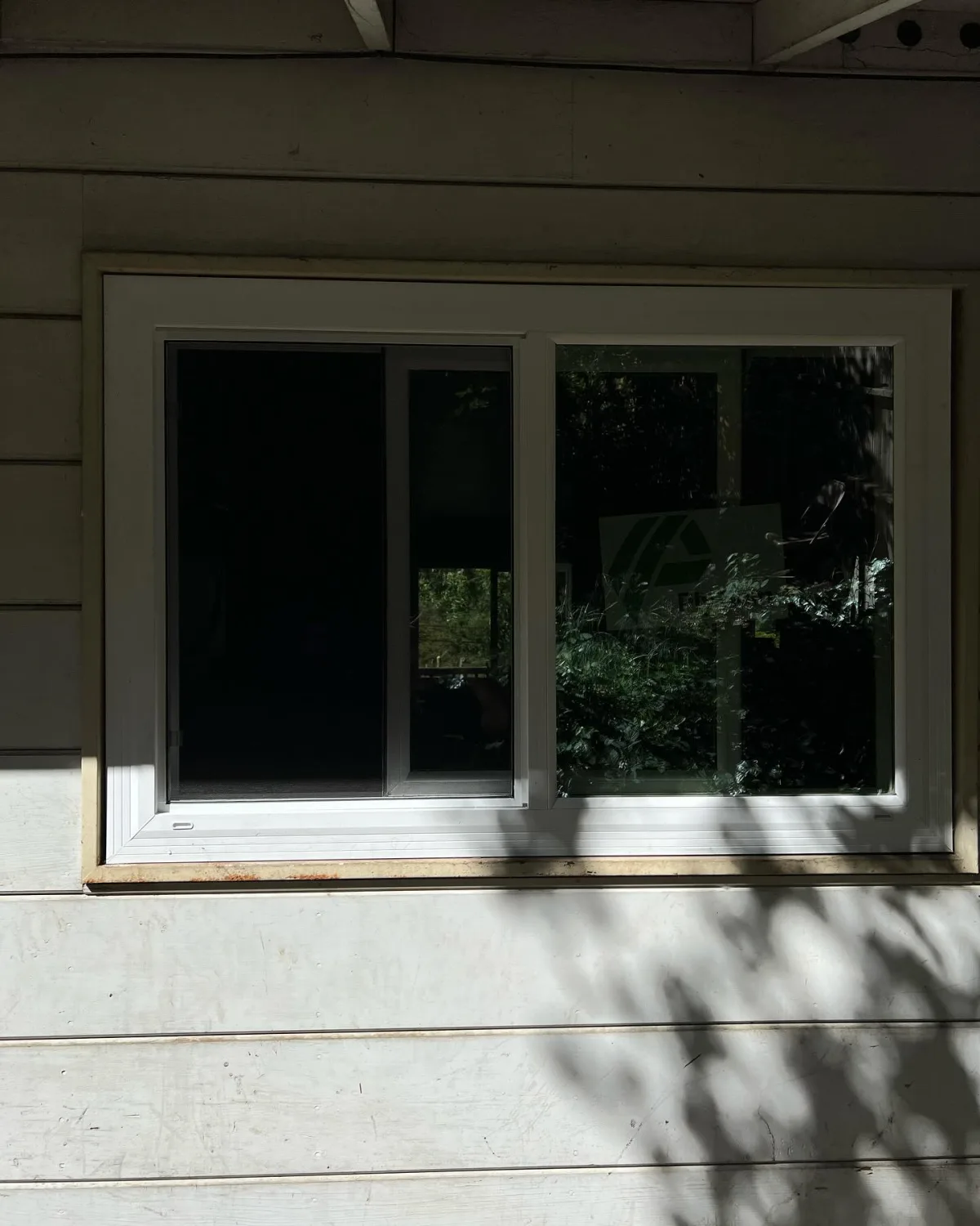 Exterior close view of a white PlyGem horizontal sliding replacement window in Oakland