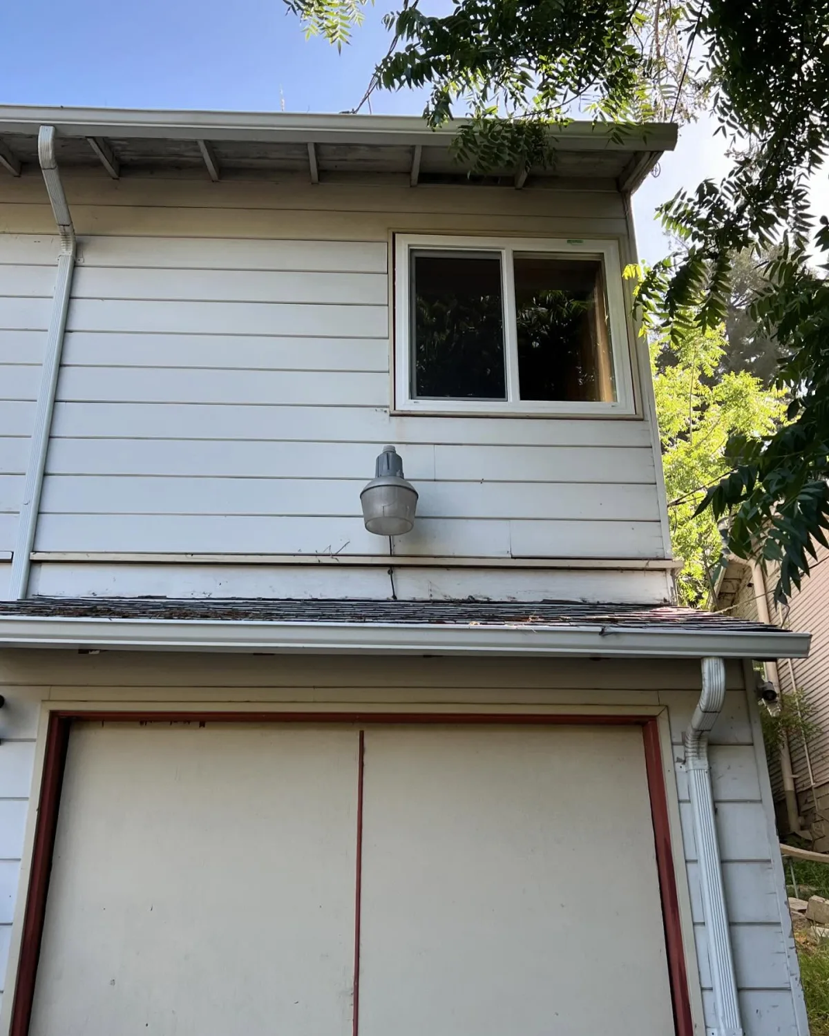 Upper-level PlyGem sliding window replacement viewed from outside an Oakland home