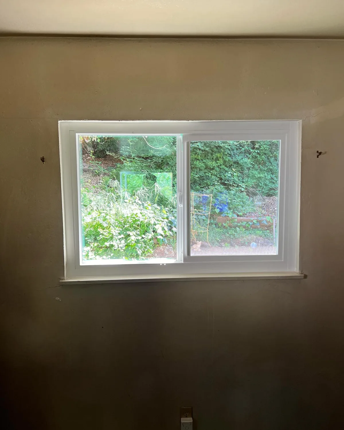 Interior view of a white PlyGem sliding replacement window in an Oakland home